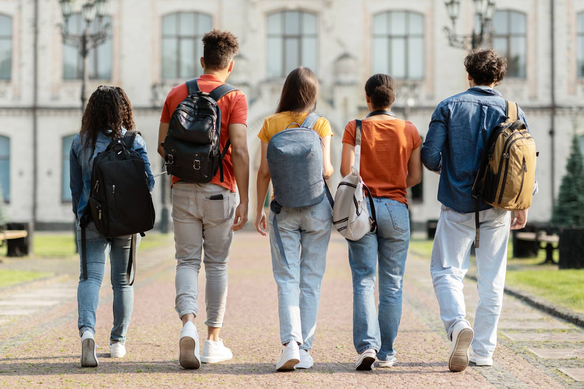 group-five-students-with-backpacks-walking-university-campus-together image